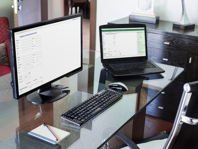 Photo of a laptop with a form developed in Excel and a desktop with the same form as a web page in Google Chrome