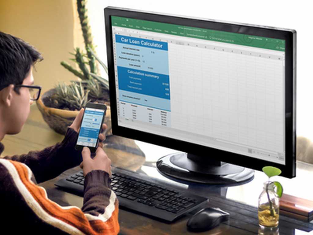 Photo of a support engineer with the same calculator on his desktop and smartphone screen