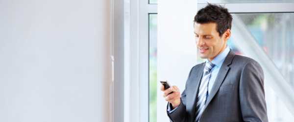 Photo of business man texting on cellphone