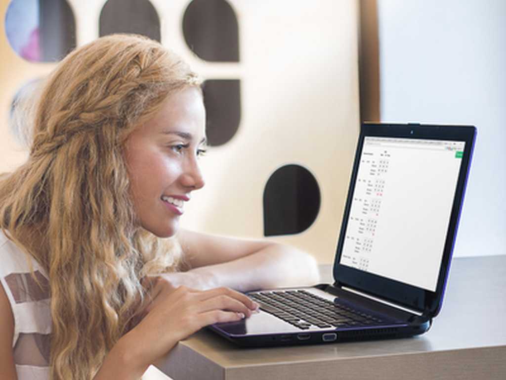 Photo of a girl evaluating football odds on a laptop