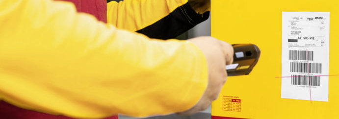 Photo of a Fedex employee scanning a barcode on a parcel