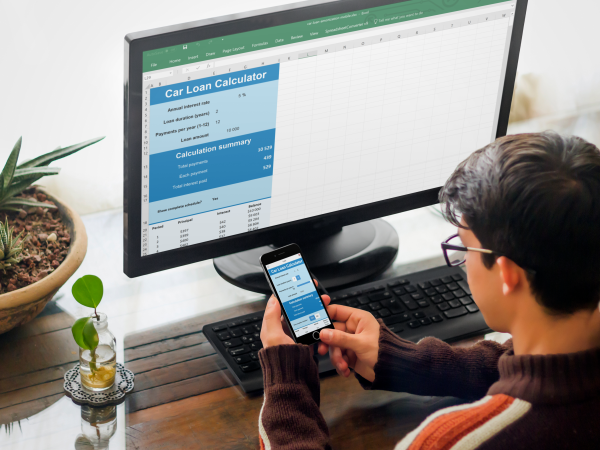 Photo of a man working with a Car Loan calculator in Excel with a Live Preview in his phone